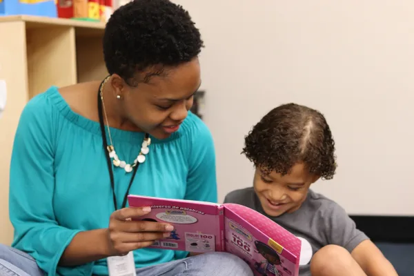 A teacher reading to a student