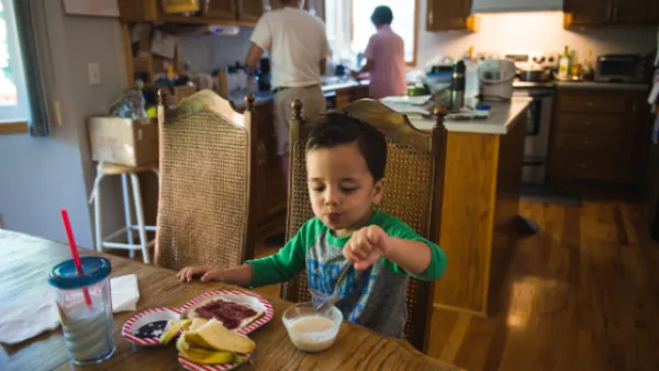Child sitting at the dinner table eating