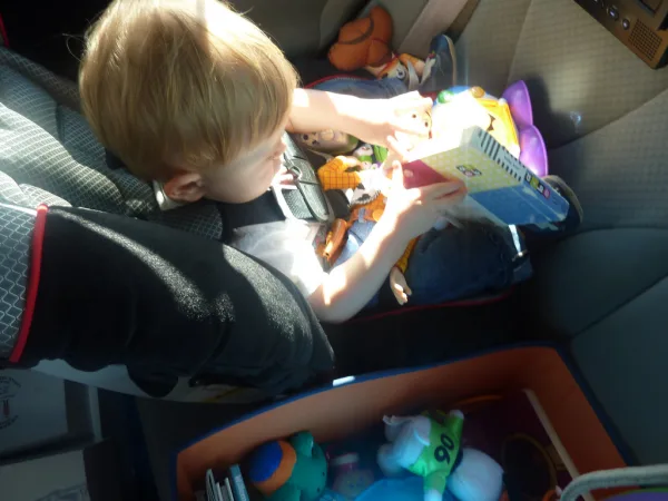 Child in car seat reading a board book