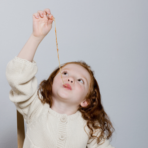 Pre-k child eating spaghetti