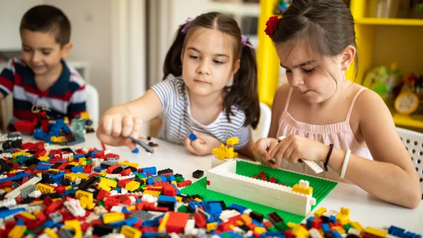 Three children playing with legos