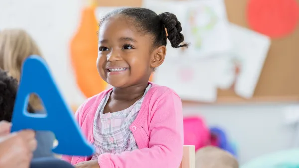 Happy child with a letter learning with early learning childhood activities, cognitive development in child care, age appropriate, Indiana Resources