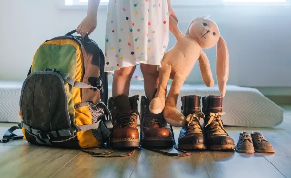 toddler standing in many shoes