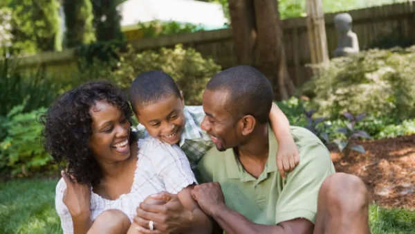 Child hugging two adults