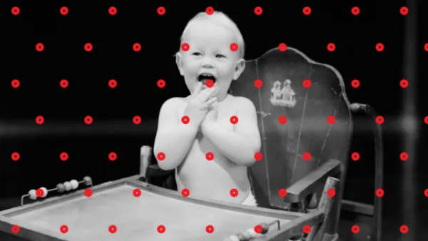 Baby sitting in high chair with red dots over the photo