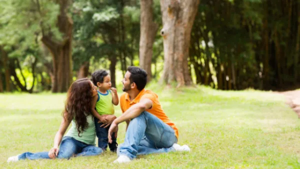A mom, dad, and child sitting outside together