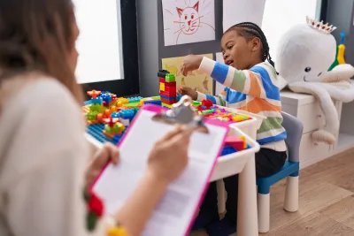 boy playing with construction blocks with observation