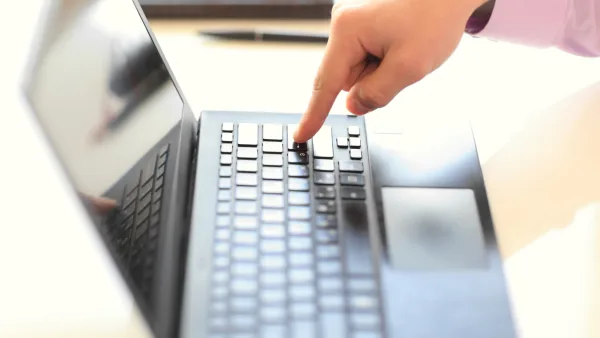 Finger pressing a button on a laptop