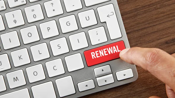 Finger pressing a button that reads "renewal" on a computer keyboard