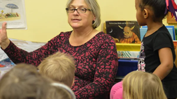 Adult reading to a group of children